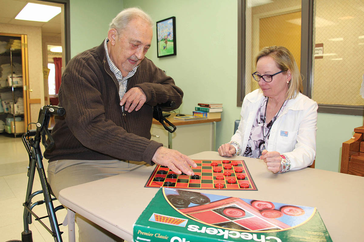 Man playing checkers at Community Memorial Hospital.