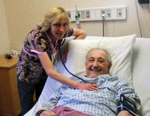 Man in hospital bed with nurse