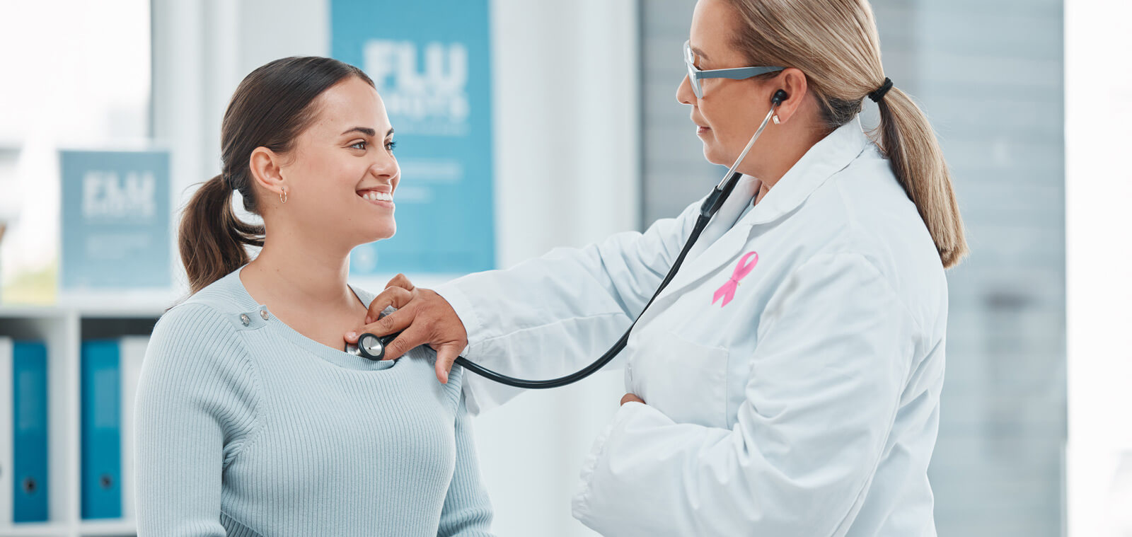 Medical provider using a stethoscope on a woman.
