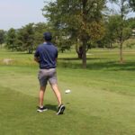 Man driving a ball on golf course