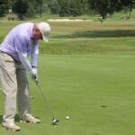 Golfer putting on green