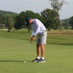 Golfers putting on a green