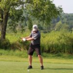 man driving a golf ball down a fairway