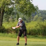 man driving a golf ball down a fairway