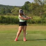 woman driving a golf ball down a fairway