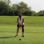 woman driving a golf ball down a fairway