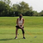 woman driving a golf ball down a fairway