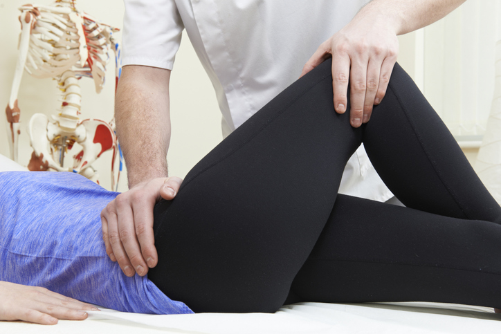 Healthcare professional testing a hip joint