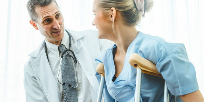 Orthopedist talking to patient on crutches